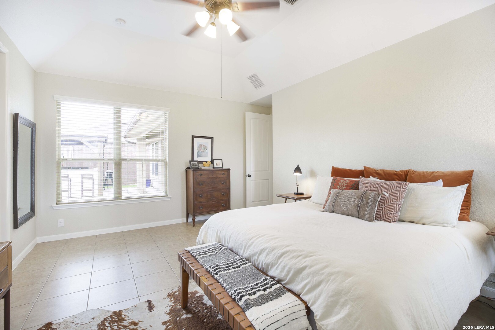 3806 Brahman Road Bulverde, TX 78163 - Photo 19 of 36 a bedroom with a large bed and a chandelier