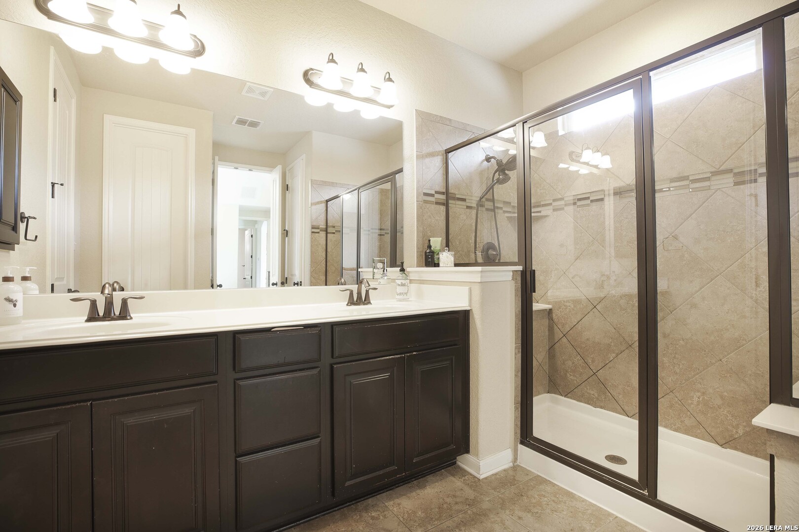 3806 Brahman Road Bulverde, TX 78163 - Photo 22 of 36 a bathroom with a double vanity sink and mirror