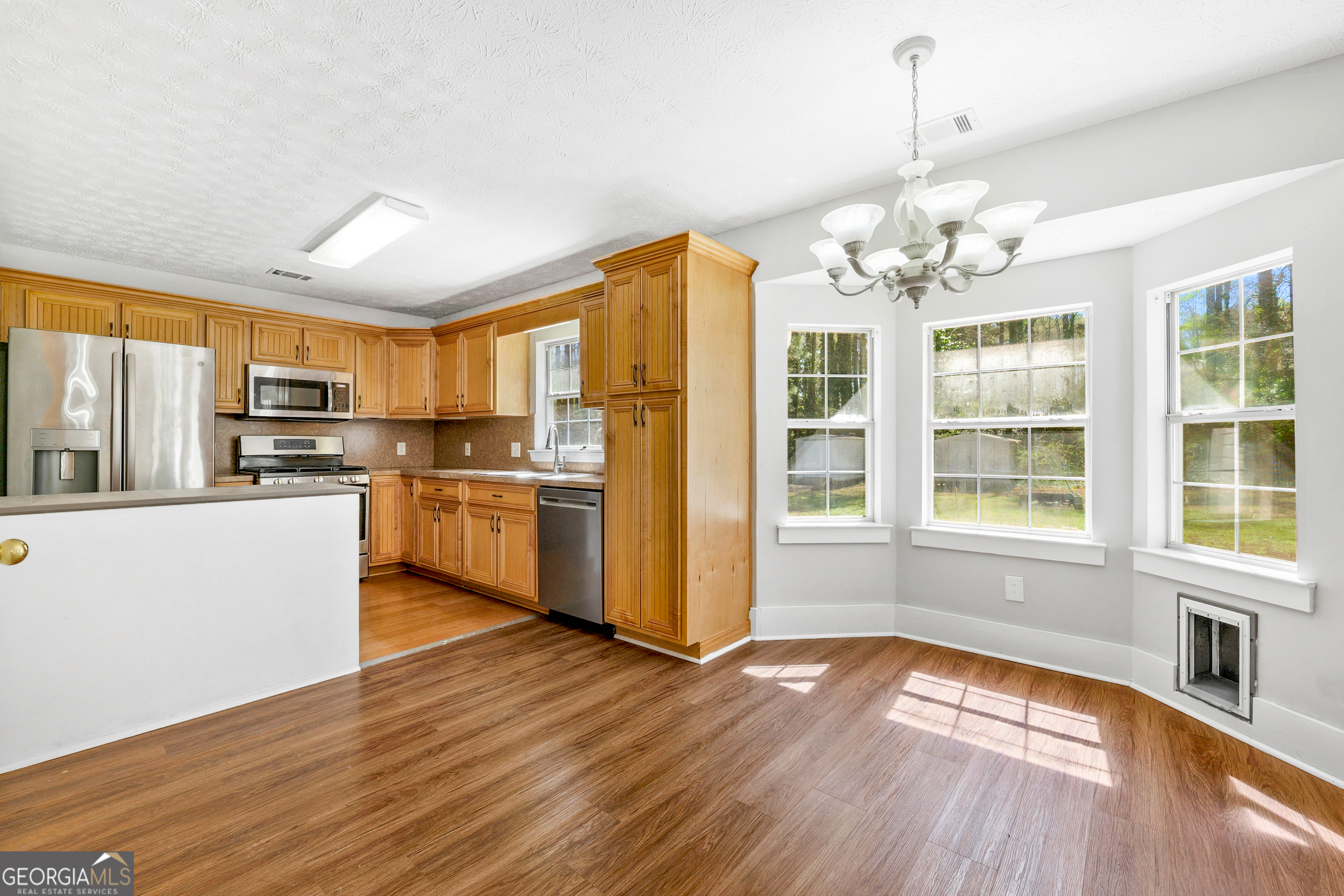108 Nicki Court Hampton, GA 30228 - Photo 5 of 27 a open kitchen with stainless steel appliances granite countertop a refrigerator a stove top oven and a large window with wooden floor