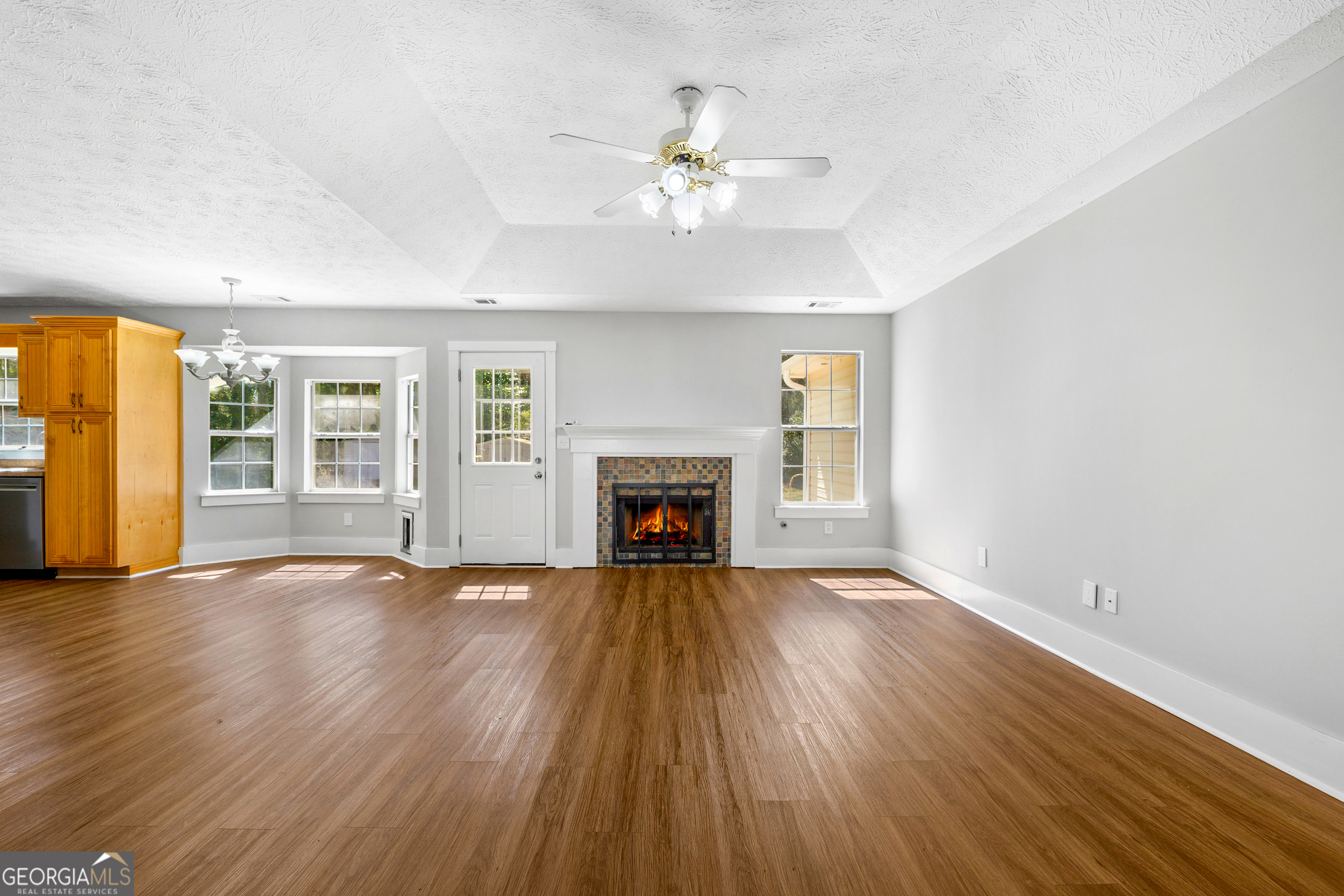 108 Nicki Court Hampton, GA 30228 - Photo 6 of 27 an empty room with wooden floor fireplace and windows
