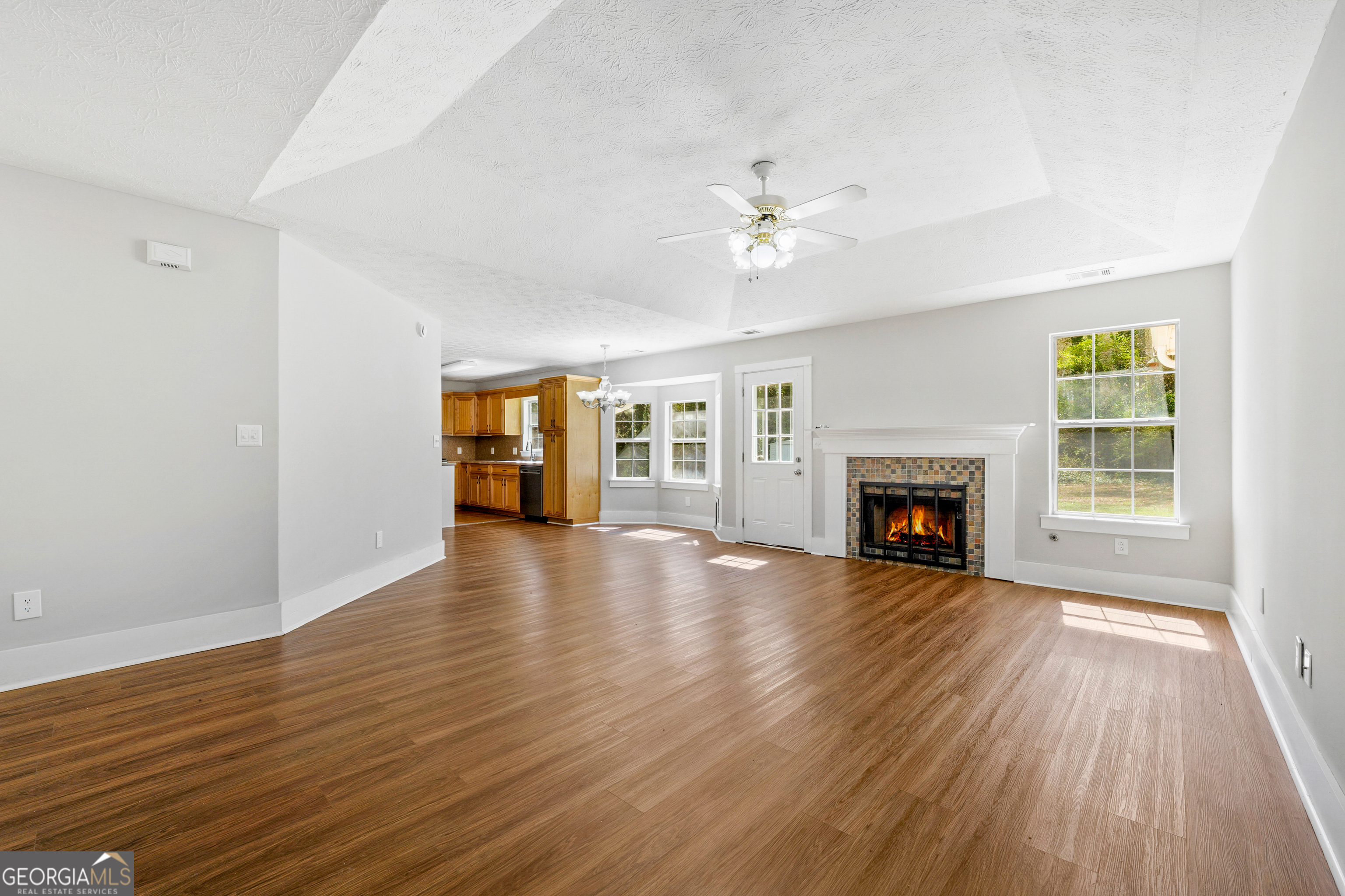 108 Nicki Court Hampton, GA 30228 - Photo 9 of 27 an empty room with wooden floor fireplace and windows