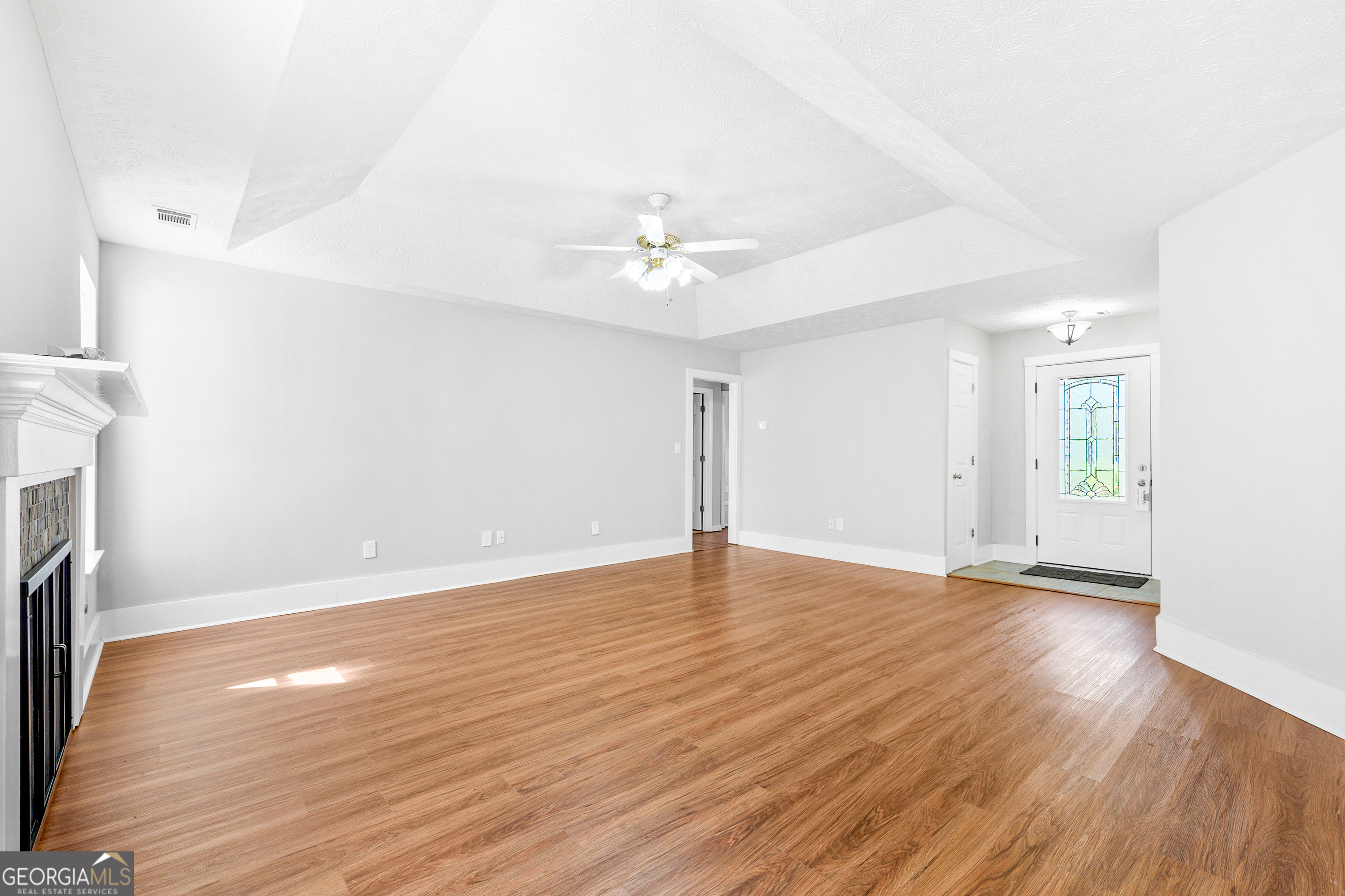 108 Nicki Court Hampton, GA 30228 - Photo 10 of 27 an empty room with wooden floor and a ceiling fan