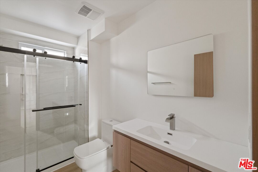 15211 1/2 Morrison Street Sherman Oaks, CA 91403 - Photo 11 of 16 a bathroom with a sink mirror toilet and shower