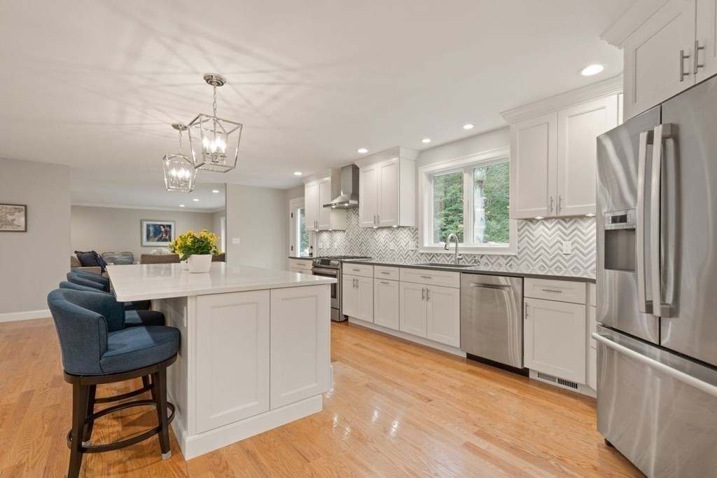 21 Elm Street Canton, MA 02021 - Photo 16 of 39 a kitchen with stainless steel appliances granite countertop a refrigerator a sink dishwasher a stove and white cabinets with wooden floor