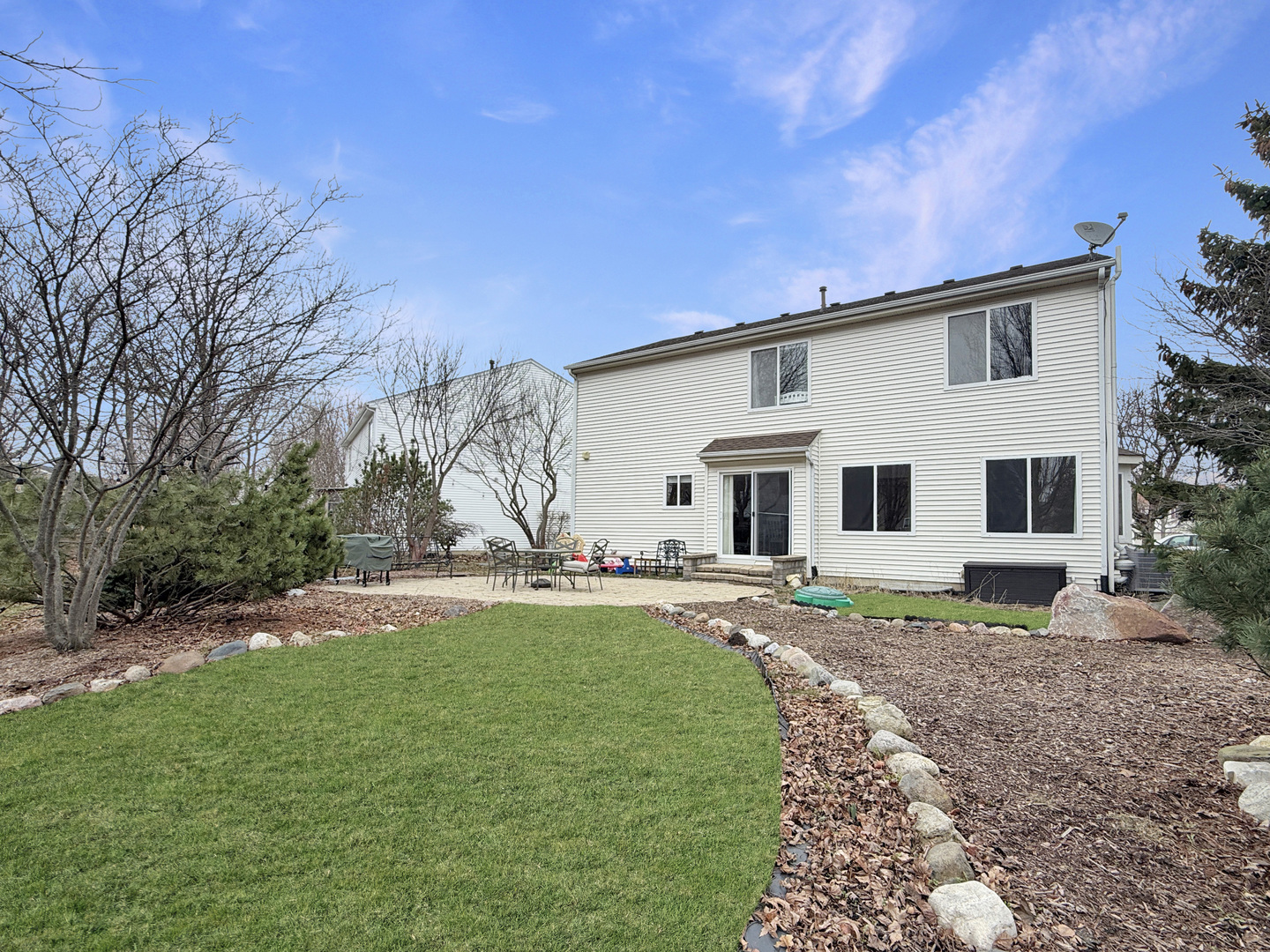 1114 Port Royal Road Pingree Grove, IL 60140 - Photo 22 of 25 a view of a white house with a big yard and large trees