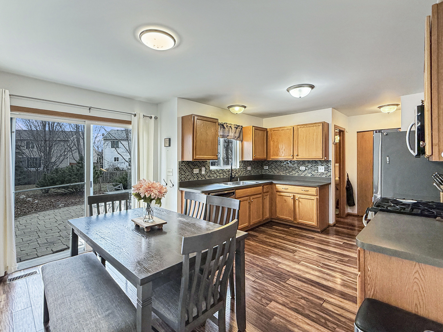 1114 Port Royal Road Pingree Grove, IL 60140 - Photo 7 of 25 a kitchen with granite countertop a stove a sink a dining table and chairs
