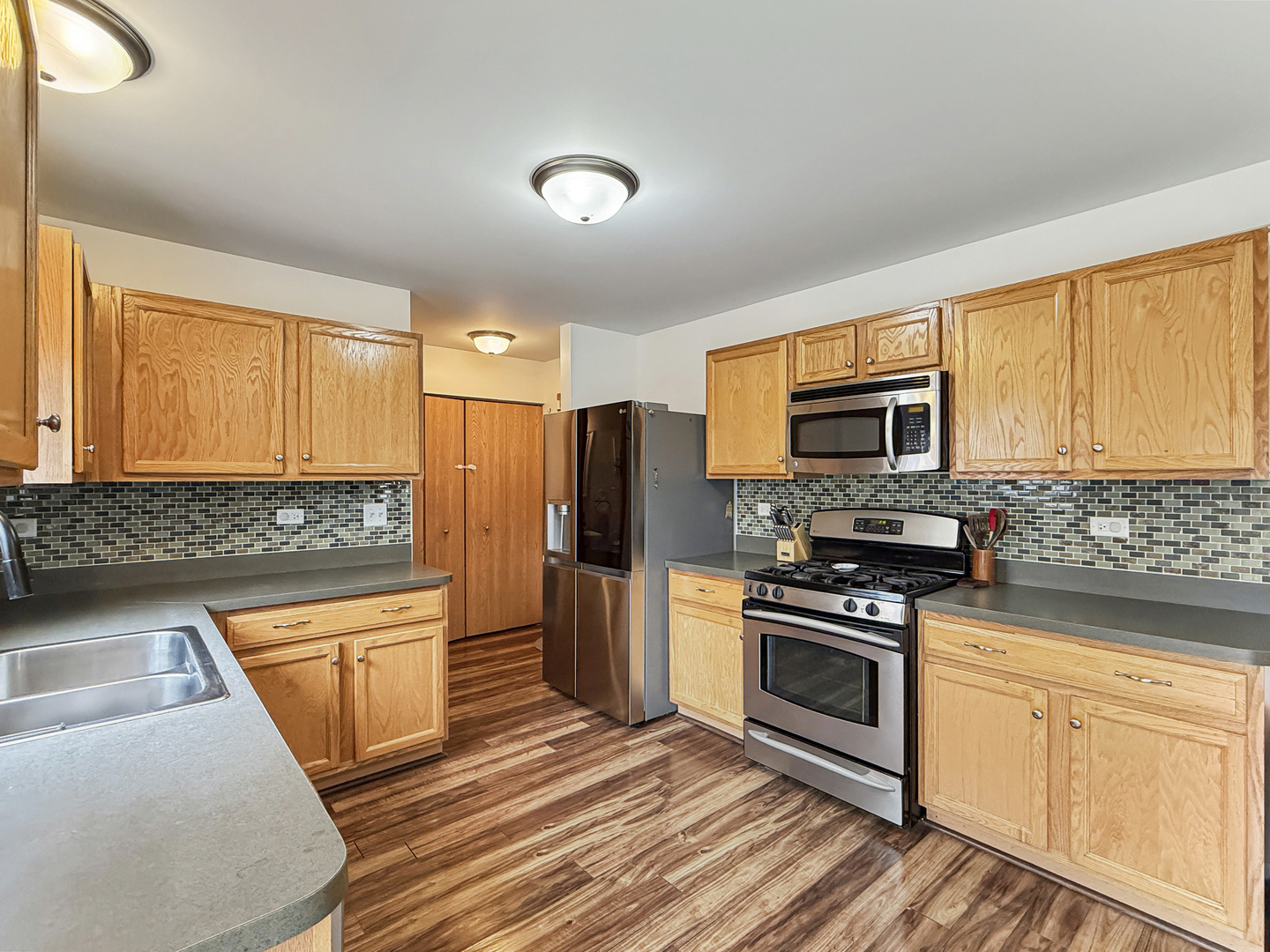 1114 Port Royal Road Pingree Grove, IL 60140 - Photo 8 of 25 a kitchen with stainless steel appliances granite countertop a refrigerator a stove top oven a sink dishwasher and white cabinets with wooden floor