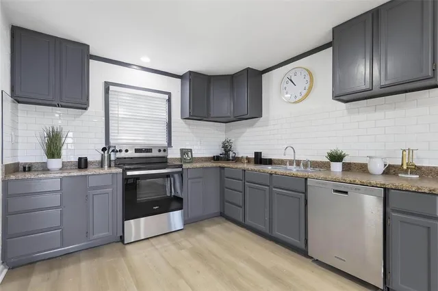 a kitchen with granite countertop a refrigerator stove and sink