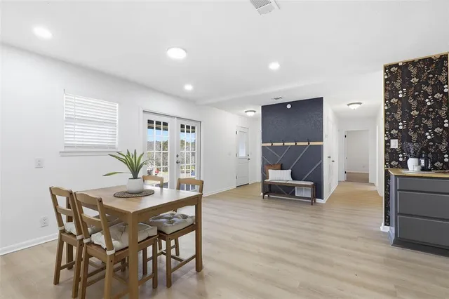 a living room with stainless steel appliances furniture and wooden floor