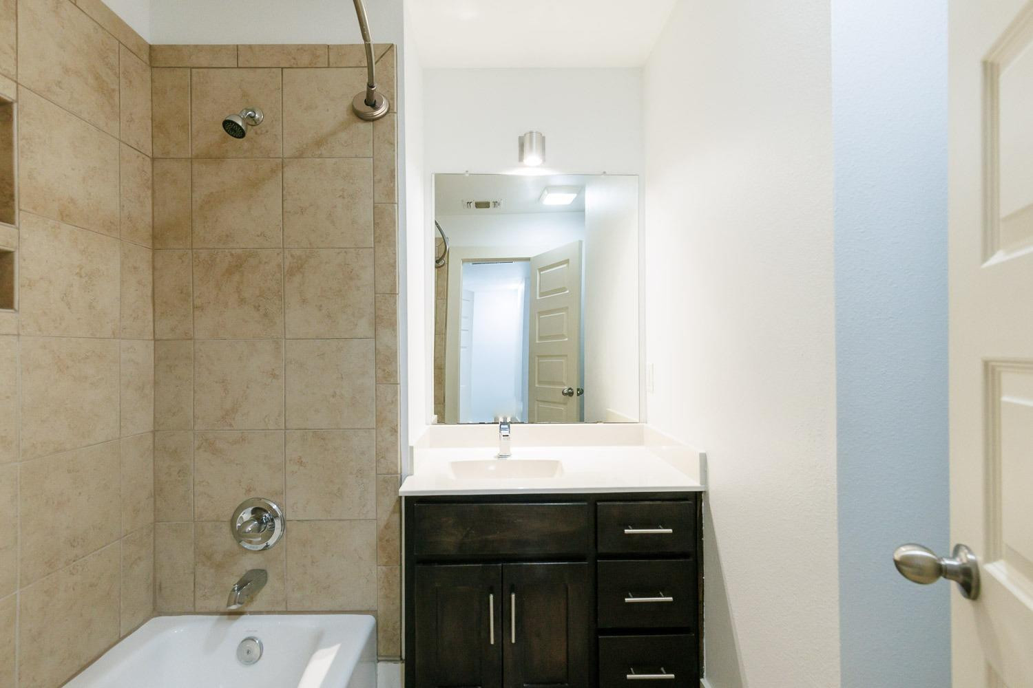 4612 121st Street Lubbock, TX 79424 - Photo 18 of 26 a bathroom with a sink a mirror and shower