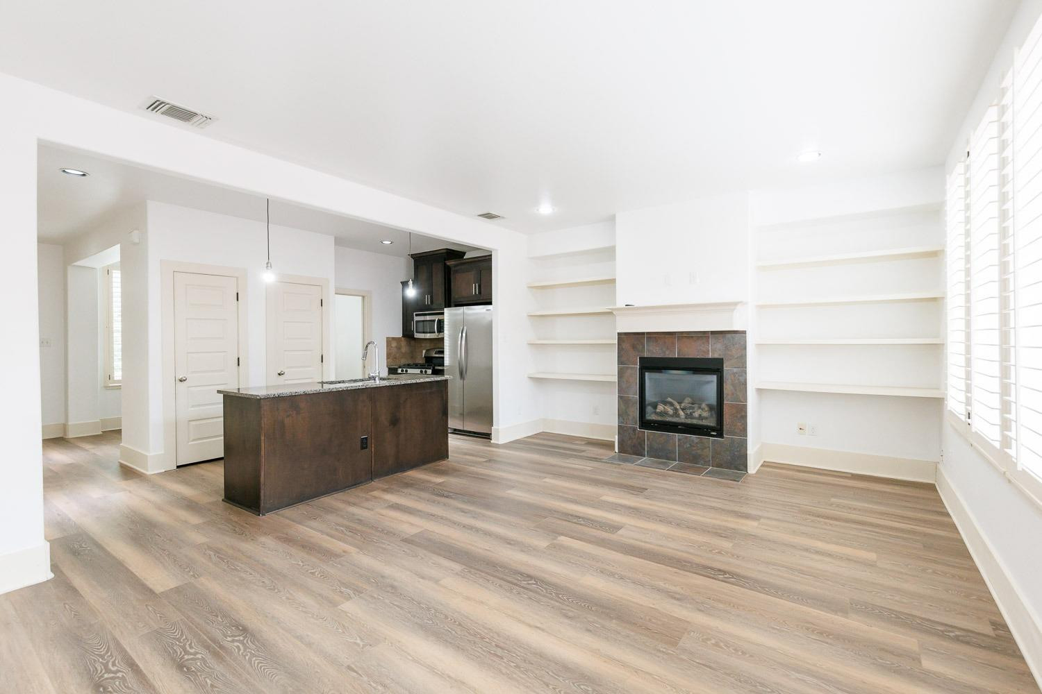 4612 121st Street Lubbock, TX 79424 - Photo 9 of 26 a large white kitchen with cabinets a sink and a fireplace