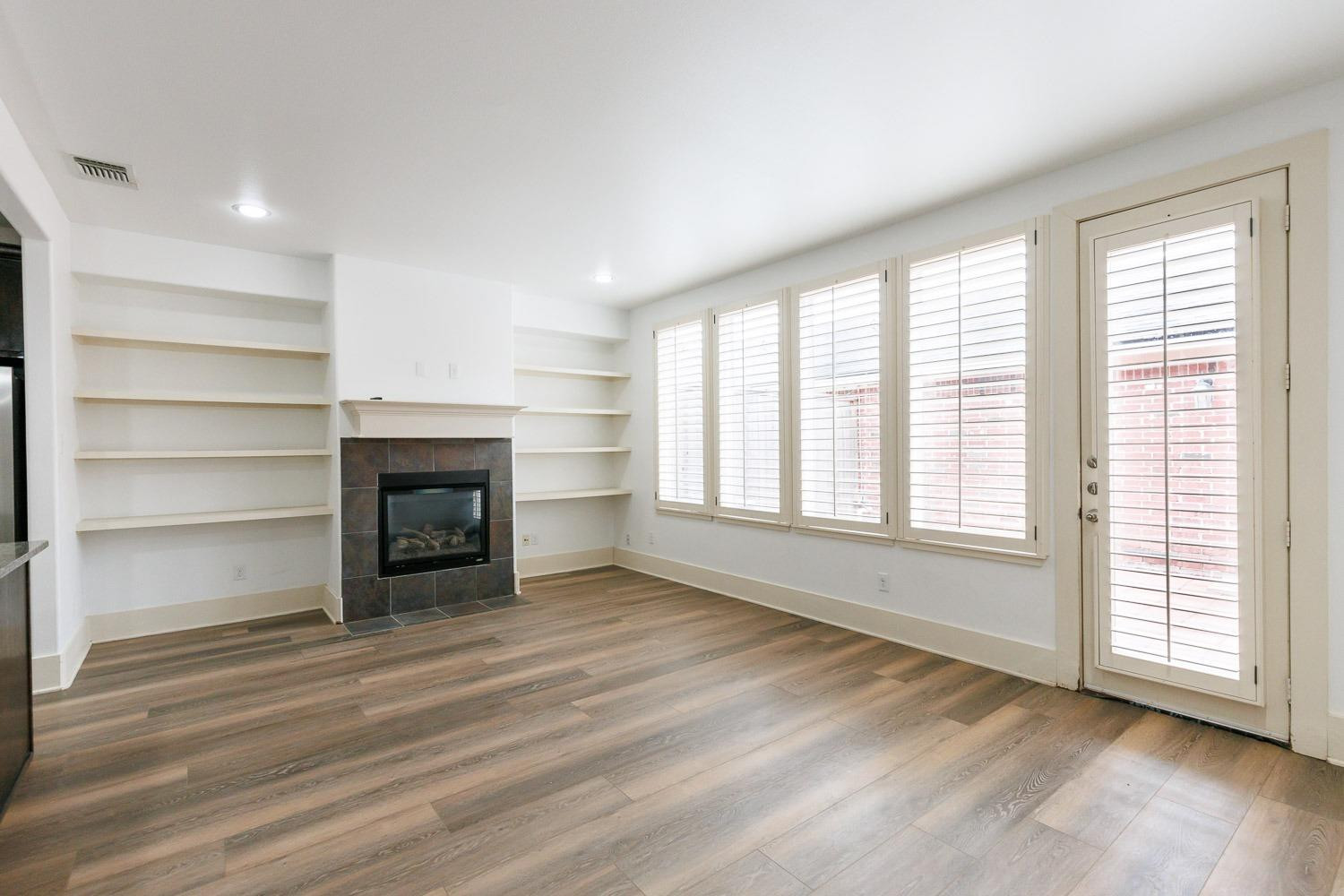 4612 121st Street Lubbock, TX 79424 - Photo 10 of 26 a view of empty room with wooden floor and fireplace