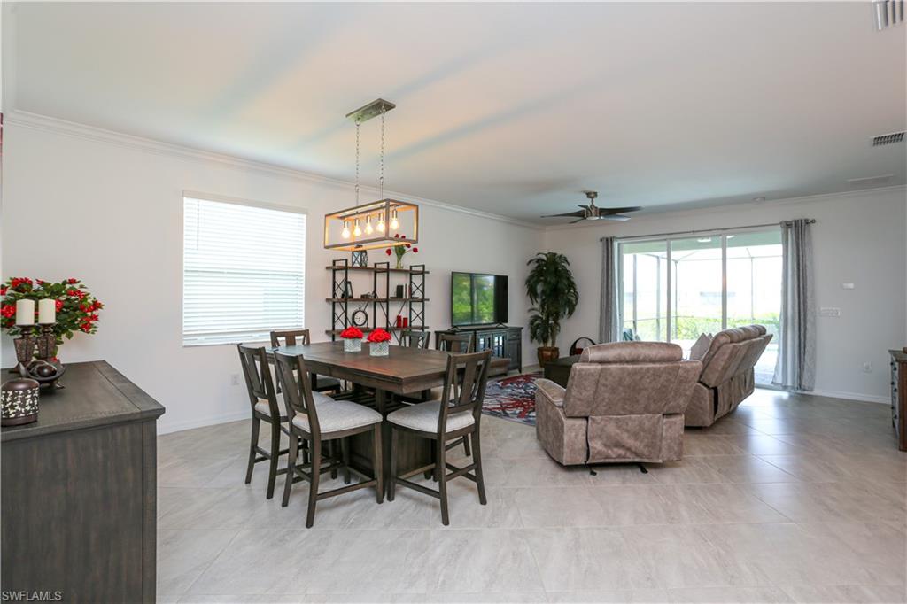 2155 Hamlin Street Naples, FL 34120 - Photo 39 of 50 Tiled dining space with ceiling fan with notable chandelier and crown molding