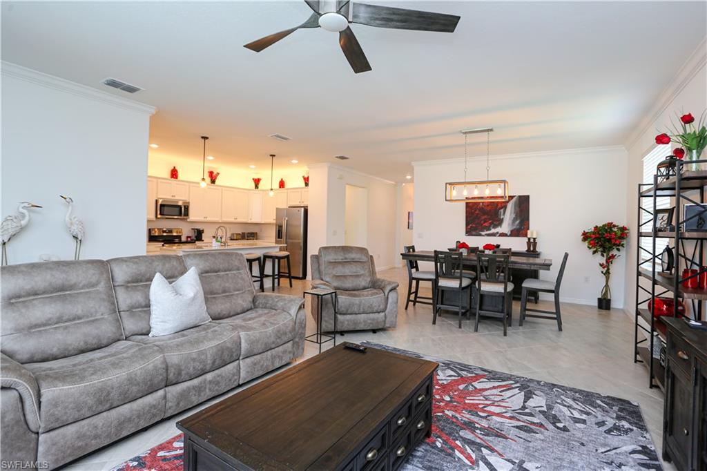 2155 Hamlin Street Naples, FL 34120 - Photo 48 of 50 Living room with ceiling fan with notable chandelier and ornamental molding