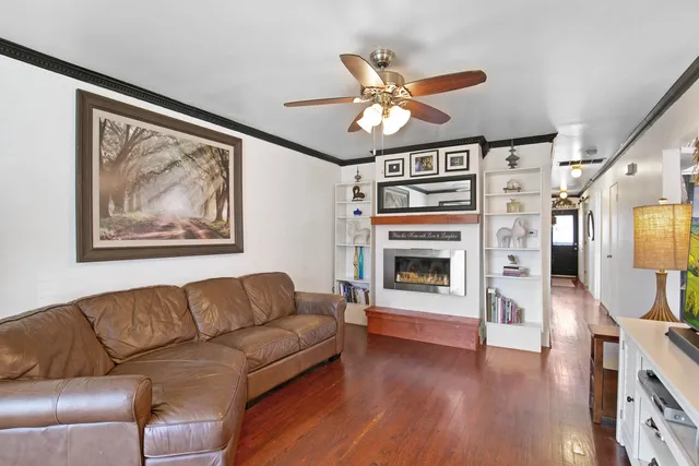 a living room with furniture a fireplace and wooden floor