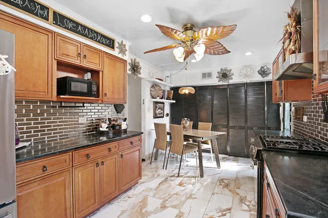 a kitchen with stainless steel appliances kitchen island granite countertop a sink and cabinets