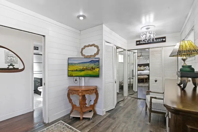 a living room with furniture a chandelier and wooden floor
