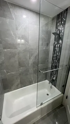 a bathroom with a shower and a bath tub