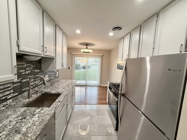 a kitchen with a refrigerator sink and stove