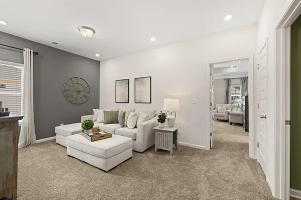 a living room with furniture a flat screen tv and a window