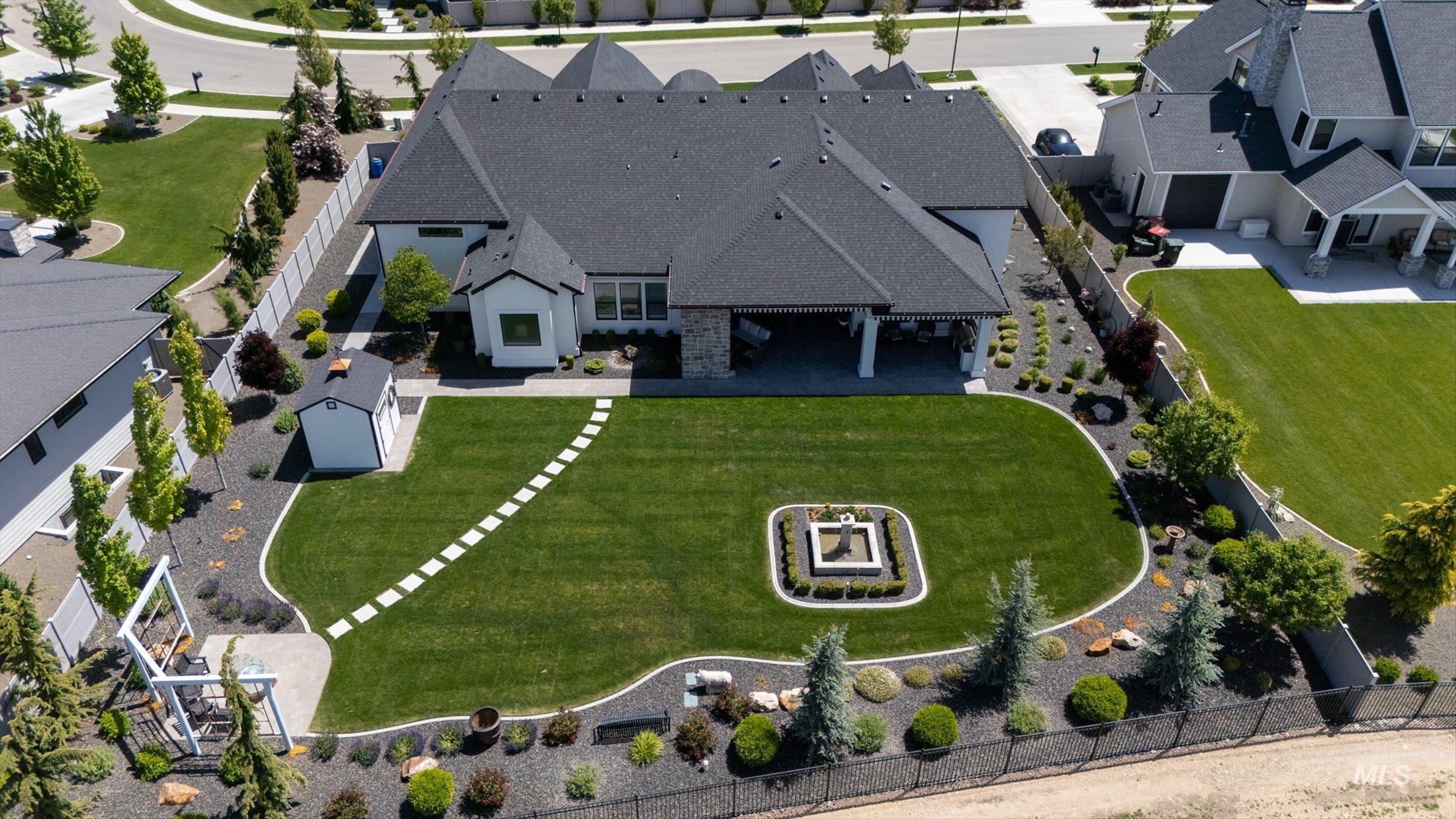 6585 South Pemberley Way Meridian, ID 83642 - Photo 4 of 43 Expansive backyard featuring a manicured lawn, established landscaping, and a decorative water feature