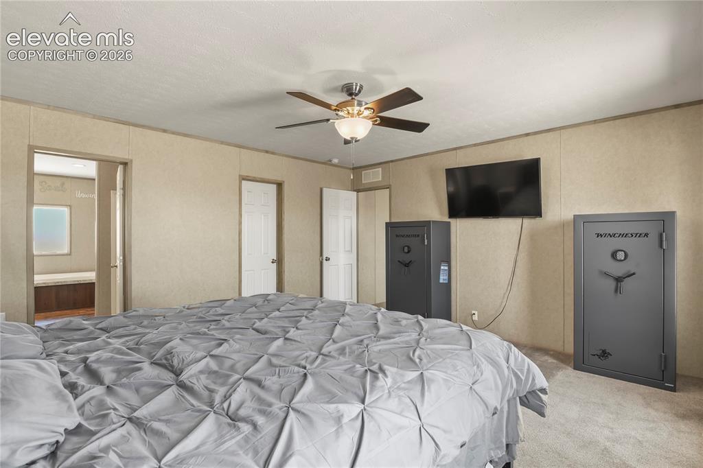22280 Jones Road Peyton, CO 80831 - Photo 17 of 47 a bedroom with a bed and a flat screen tv