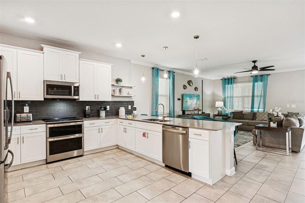 2949 Protagonist Street Kissimmee, FL 34746 - Photo 8 of 93 a kitchen with white cabinets and appliances