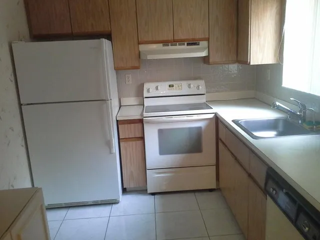 a kitchen with a refrigerator sink and cabinets
