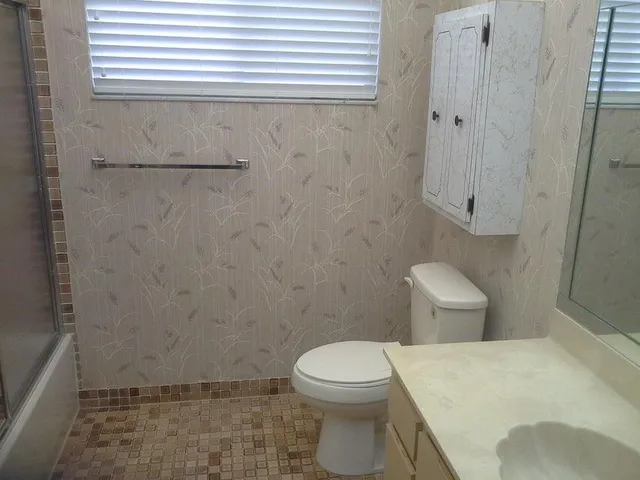a white toilet sitting next to a shower curtain