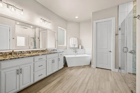 a bathroom with a granite countertop sink and a bathtub