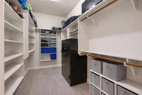 a view of walk in closet with clothes and shoes