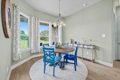 a dining room with furniture a chandelier and wooden floor