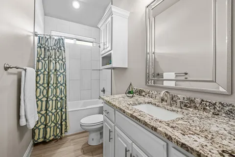 a bathroom with a granite countertop sink toilet and shower