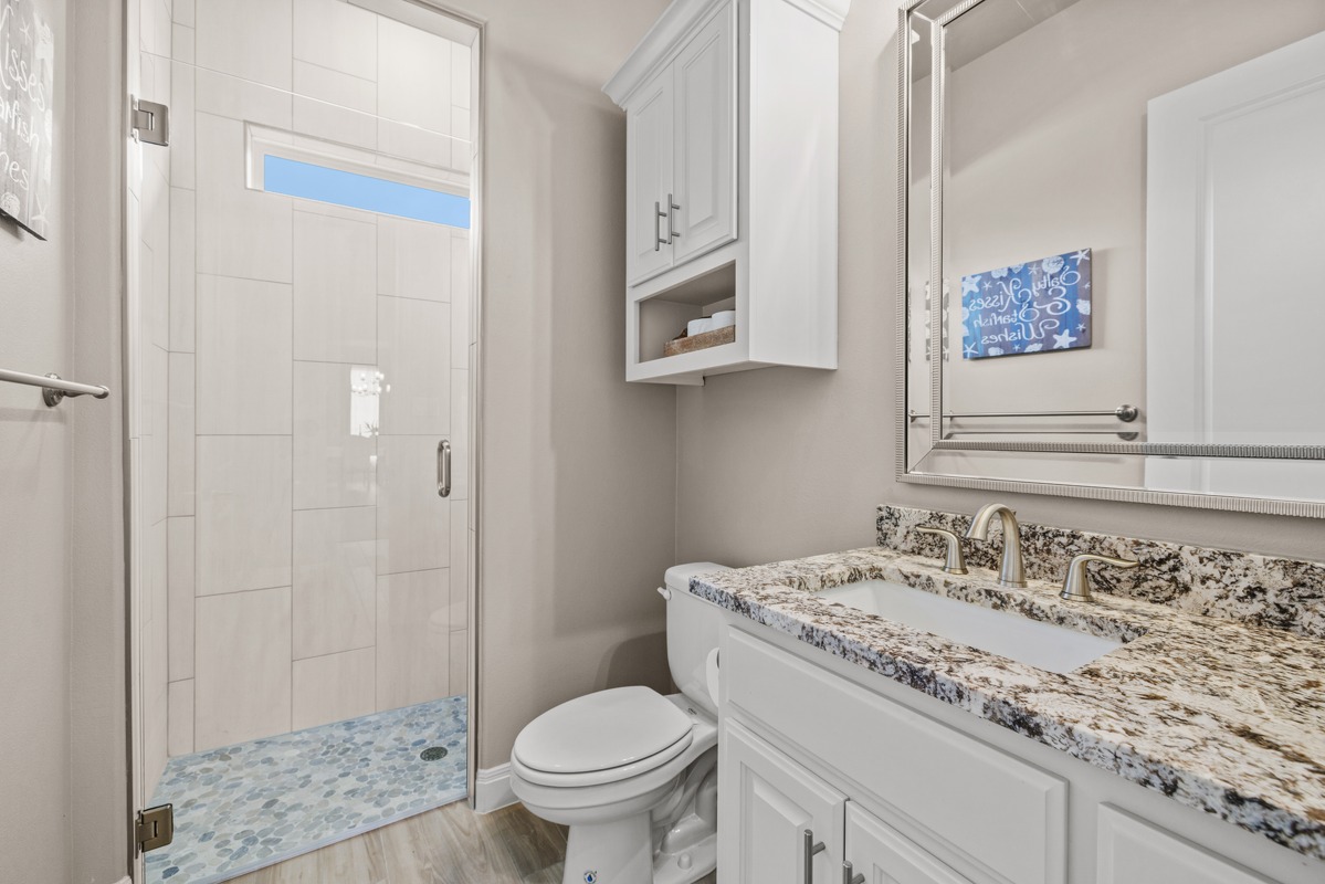 329 Independence Drive Georgetown, TX 78633 - Photo 25 of 34 a bathroom with a granite countertop sink a mirror and a toilet