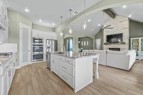 a large white kitchen with kitchen view and living room view
