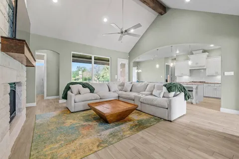 a living room with fireplace furniture and a large window