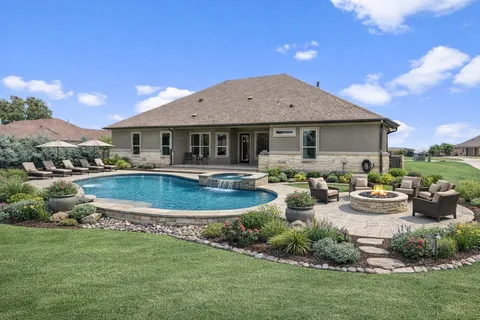 a view of a house with swimming pool and a yard