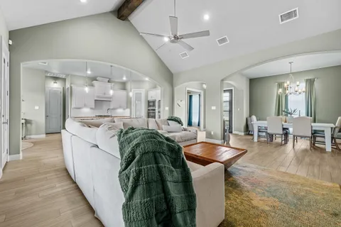 a large white kitchen with lots of counter space and chandelier