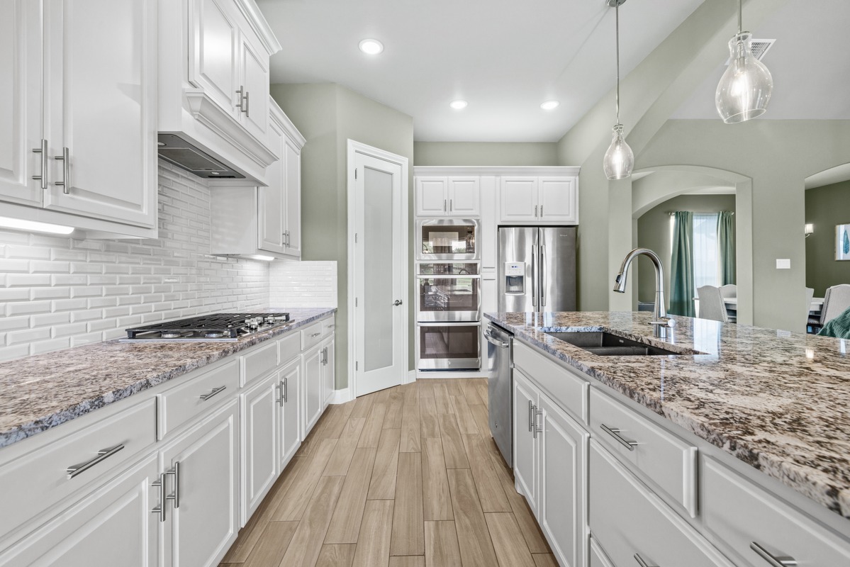 329 Independence Drive Georgetown, TX 78633 - Photo 7 of 34 a large kitchen with granite countertop a lot of counter space and wooden floor