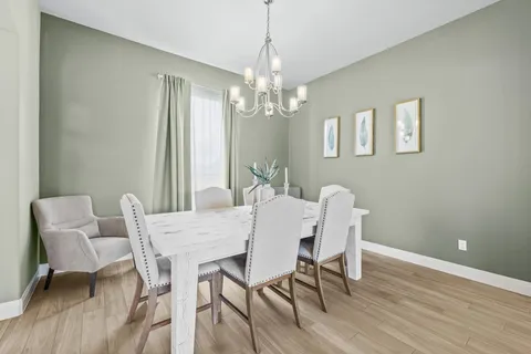 a view of a dining room with furniture a chandelier and wooden floor