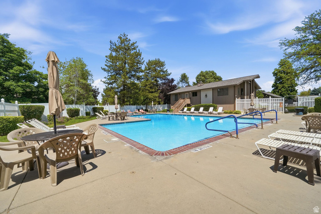 6969 South 855 East Midvale, UT 84047 - Photo 50 of 55 Rectangular swimming pool with blue handrails and a concrete surround