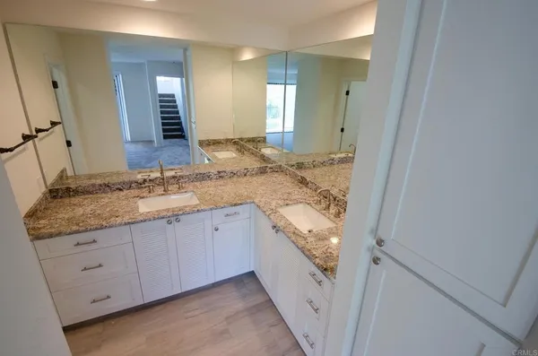 a bathroom with a granite countertop sink and a mirror
