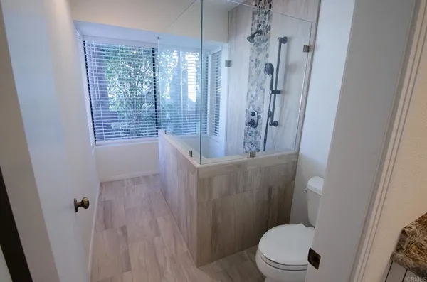 a bathroom with a toilet and a shower