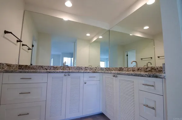 a bathroom with a granite countertop sink and a mirror