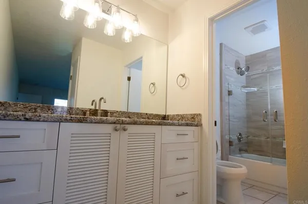 a bathroom with a granite countertop toilet a sink and a bathtub