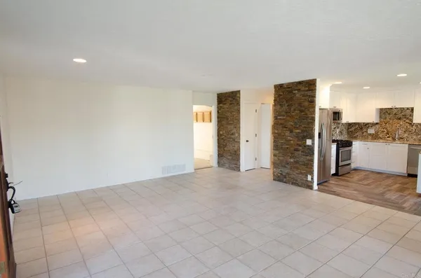 an empty room with kitchen view