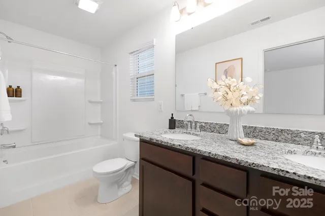 a bathroom with a granite countertop sink a toilet and bathtub
