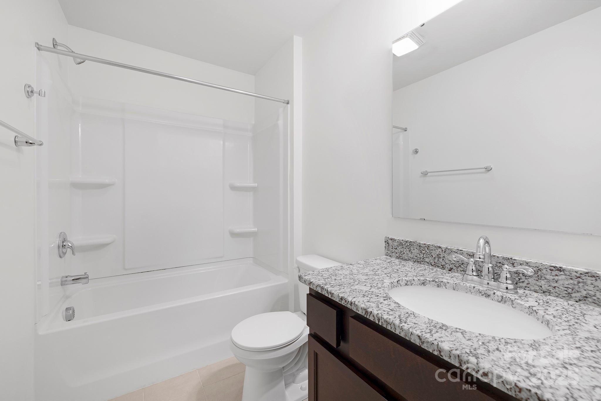 12970 Hill Pine Road, Unit 248 Midland, NC 28107 - Photo 25 of 30 a bathroom with a granite countertop sink a toilet and bathtub