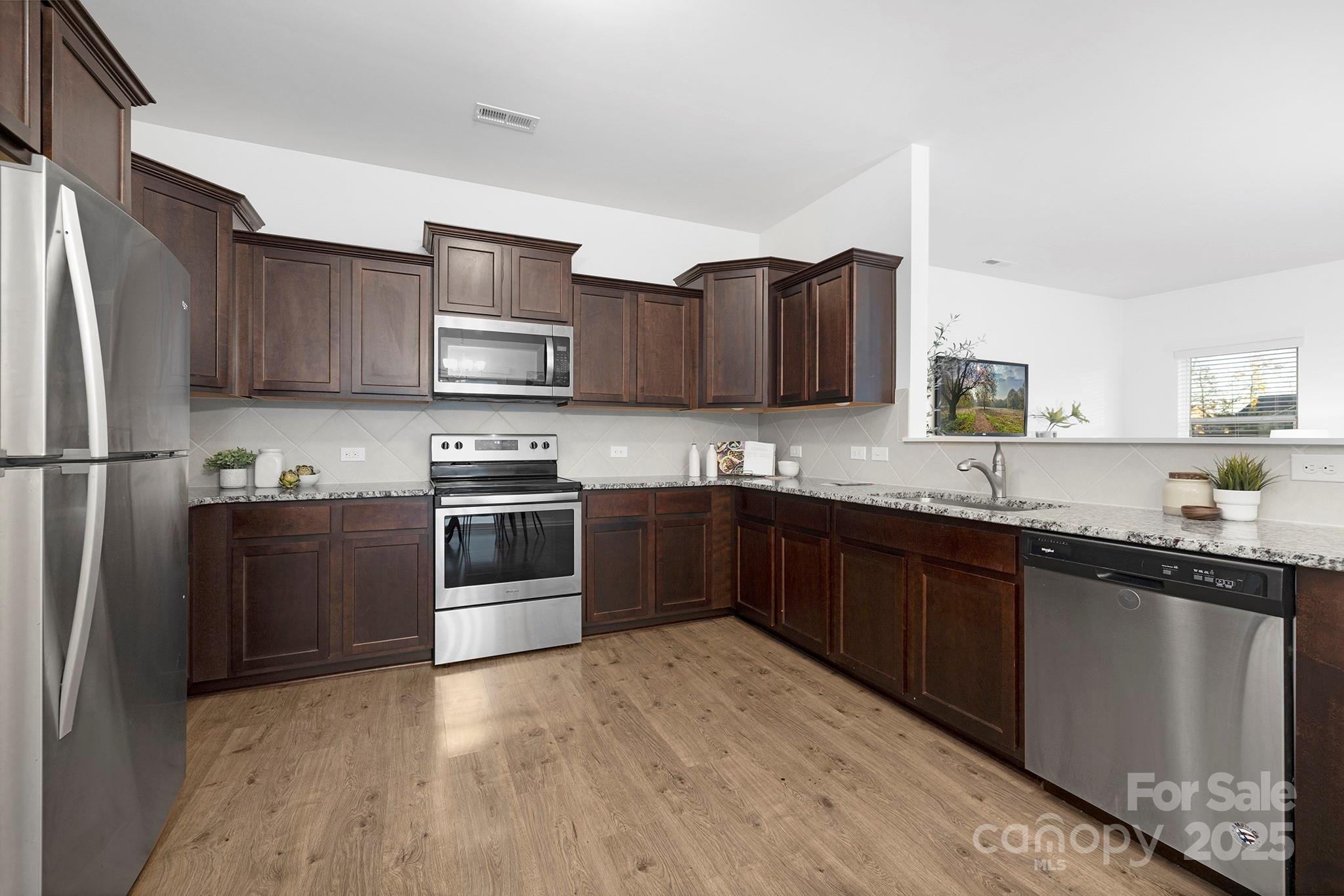12970 Hill Pine Road, Unit 248 Midland, NC 28107 - Photo 4 of 30 a kitchen with granite countertop a refrigerator stove top oven and sink