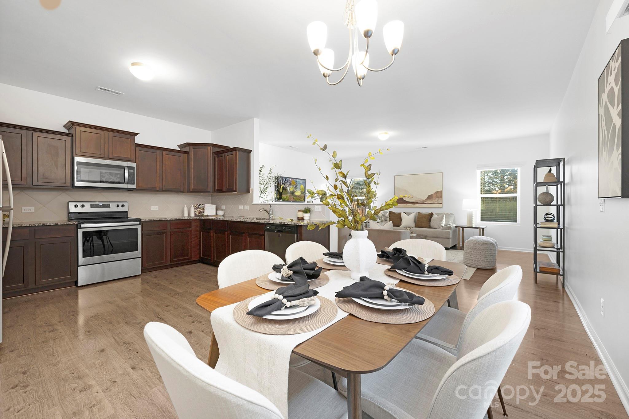 12970 Hill Pine Road, Unit 248 Midland, NC 28107 - Photo 6 of 30 a view of a dining room with furniture a kitchen and chandelier